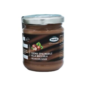 Un barattolo di vetro etichettato "Crema Nocciola" pieno di crema spalmabile alla nocciola. Il barattolo ha un coperchio argentato e l'etichetta presenta un'immagine di nocciole. Le informazioni nutrizionali e gli ingredienti sono stampati sui lati dell'etichetta.